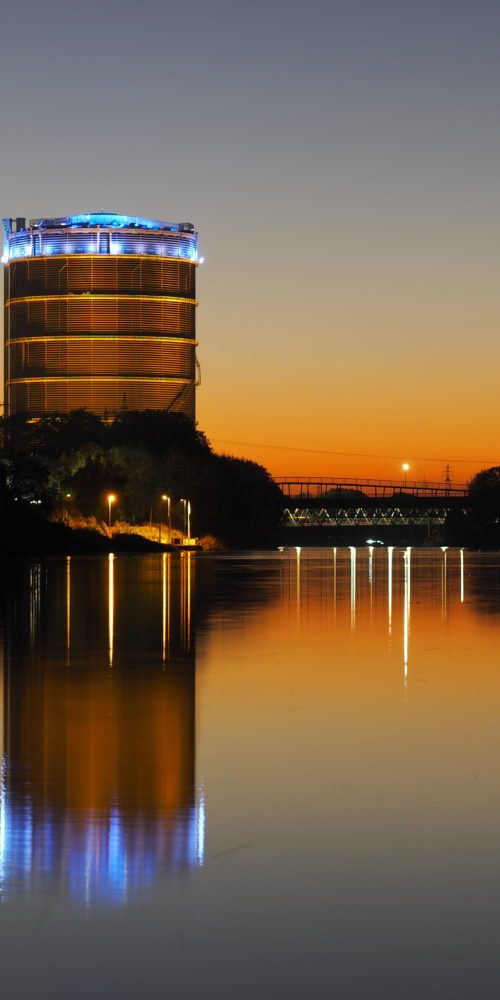 Das Foto zeigt den Gasometer Oberhausen samt Rhein-Herne-Kanal beim Sonnenuntergang