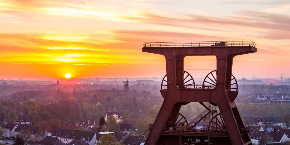 Das Foto zeigt das Fördergerüst des UNESCO-Welterbe Zollverein in Essen im Sonnenuntergang