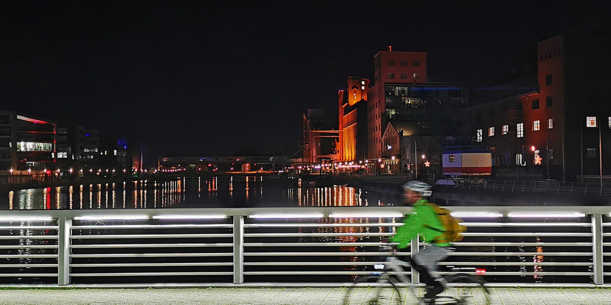 Das Foto zeigt einen Radfahrer im Innenhafen Duisburg bei einem Nightride durchs Ruhrgebiet