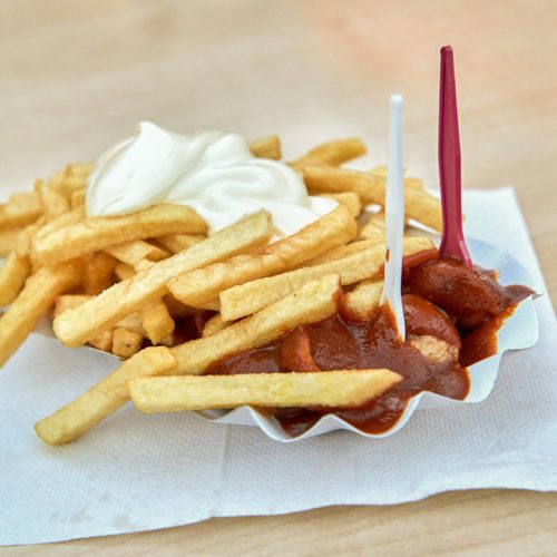 Das Bild zeigt eine Currywurst mit Pommes im Bratwursthaus