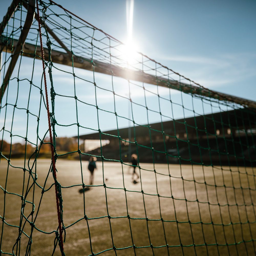 Das Bild zeigt zwei Menschen beim Fußballspielen auf der Glückauf Kampfbahn