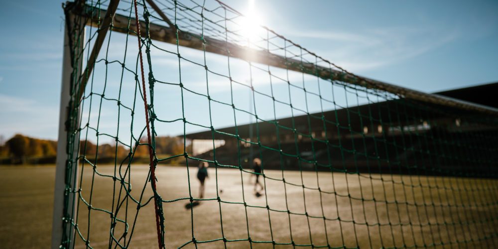 Das Bild zeigt zwei Menschen beim Fußballspielen auf der Glückauf Kampfbahn