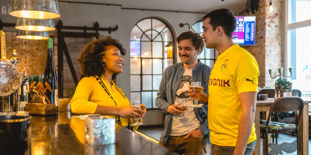 Das Bild zeigt drei Menschen an der Theke in der Gastronomie Mit Schmackes in Dortmund