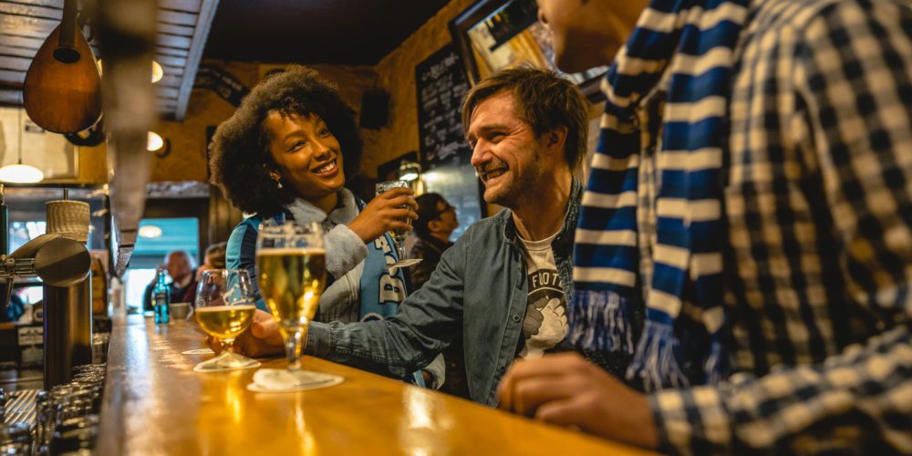 Das Bild zeigt eine Gruppe Menschen an der Theke in der Pinte in Bochum