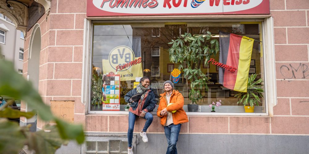 Das Bild zeigt ein Paar vor einer Pommesbude in Dortmund