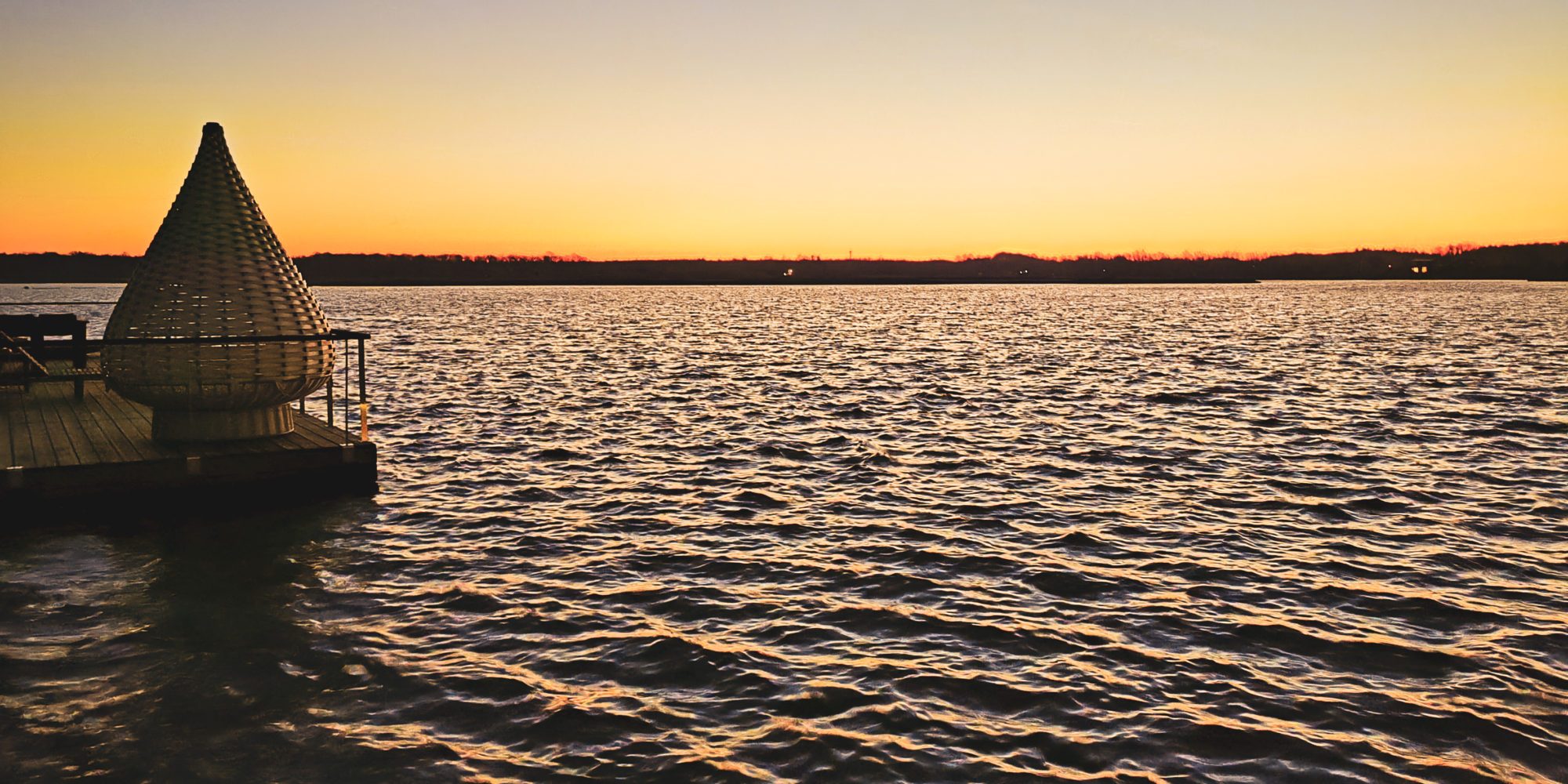 写真は、ヴェーゼルのニーダーラインハウスボートでのディアスフォードターヴァルトゼーに沈む夕日を示しています
