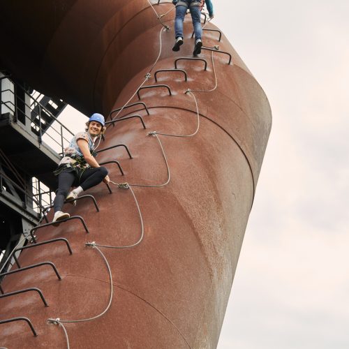 Zdjęcie przedstawia osobę wspinającą się w parku krajobrazowym Duisburg-Nord