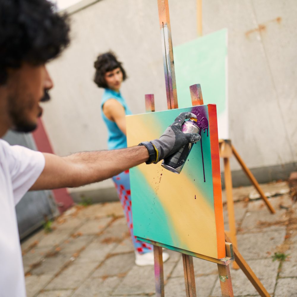 Resim, bir grafiti atölyesinde iki kişiyi gösteriyor.